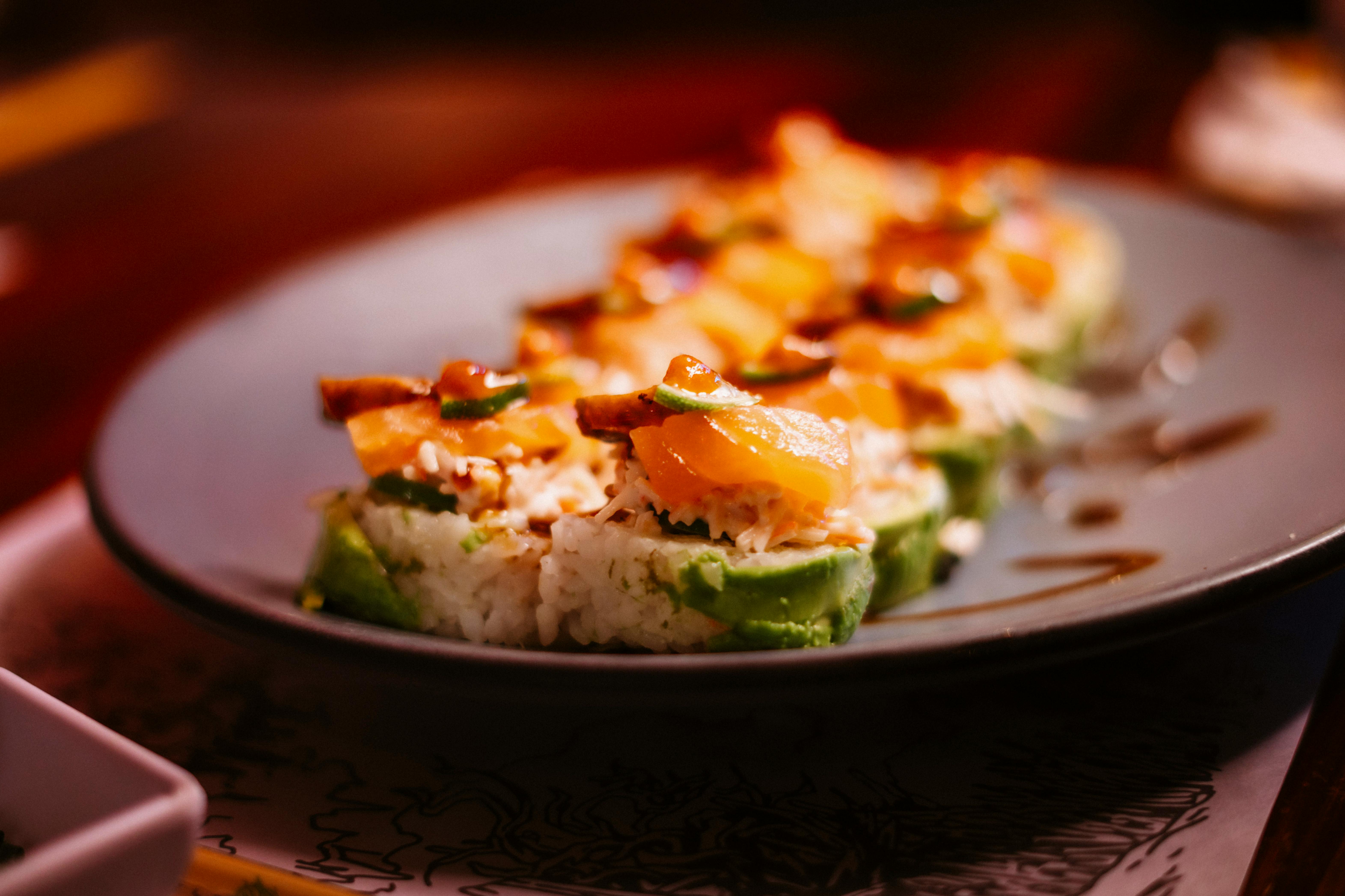 Imatge amb un plat en primer pla, amb menjar fred. Costa reconèixer la imatge però sembla menjar japonès. 